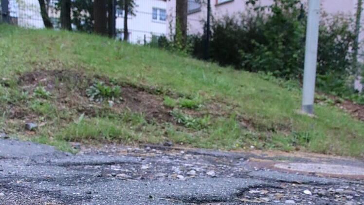 Der Zustand der Asphaltdecke im Friedrich-Fröbel-Weg ist miserabel, bemängelt Anwohner Horst Dietrich. Augenscheinlich hat er damit nicht unrecht, die Stadt Ebern hat erklärt, sich der Sache anzunehmen. Foto: Andreas Lösch