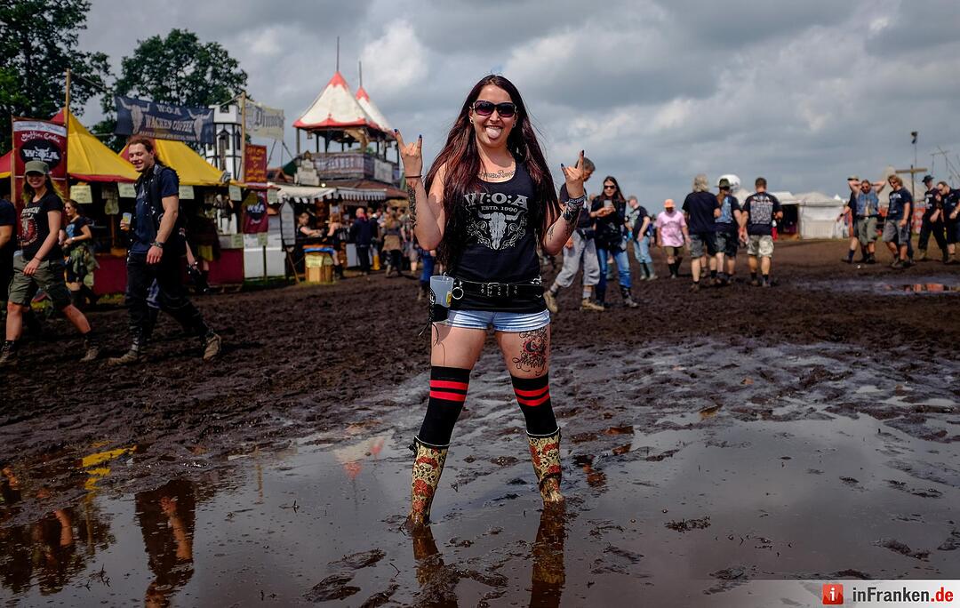 Metal-Fans feiern am 04.08.2016 in Wacken (Schleswig-Holstein) auf dem Gelände des Wacken Open Air im Matsch. Das Gelände des nach Veranstalterangaben größten Metal Festivals ist nach starken Regenfällen mit Schlamm überzogen.