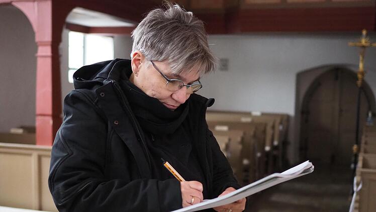 Birgit Kleefeld, angehende Glockensachverständige, macht sich Notizen zu den Glocken der Kirche in Seidmannsdorf.  
