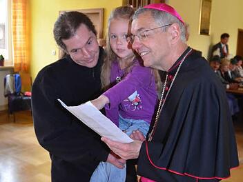 Sichtlich erfreut nahm Erzbischof Ludwig Schick in Pressig ein Gemälde-Geschenk von der fünfjährigen Hanna mit deren Signatur entge-gen. Foto: K.-H. Hofmann