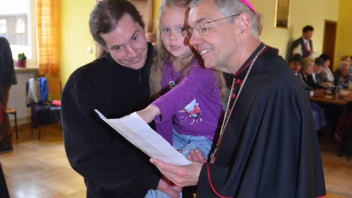 Sichtlich erfreut nahm Erzbischof Ludwig Schick in Pressig ein Gemälde-Geschenk von der fünfjährigen Hanna mit deren Signatur entge-gen. Foto: K.-H. Hofmann