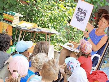 Judith Allert bei der Lesung für Kinder in ihrem Bauernhof in Püchitz. Wie in ihren Büchern illustriert sie die Texte auch bei der Lesung mit Zeichnungen, was alles noch kurzweiliger für ihr Publikum werden lässt. Foto: Matthias Einwag