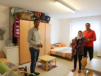 Ein Zimmer für drei Erwachsene und ein Baby: Rimal Ililati sehnt sich danach, bald mit ihrem Töchterchen Mirvat und Ehemann Zakrya Darwisch eine eigene Wohnung zu finden. Links im Bild steht Zakryas Neffe Ibrahim Makki, der ebenfalls aus Aleppo geflüchtet ist Foto: Barbara Herbst