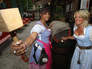 Andrea Dinkel (rechts), Wirtin im Frankendorf, und Kellnerin Jennifer Davis stechen das erste Fass an. Foto: Michael Busch