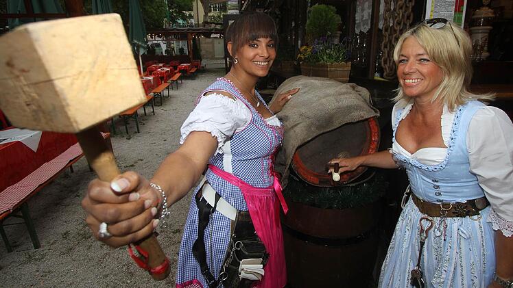 Andrea Dinkel (rechts), Wirtin im Frankendorf, und Kellnerin Jennifer Davis stechen das erste Fass an. Foto: Michael Busch