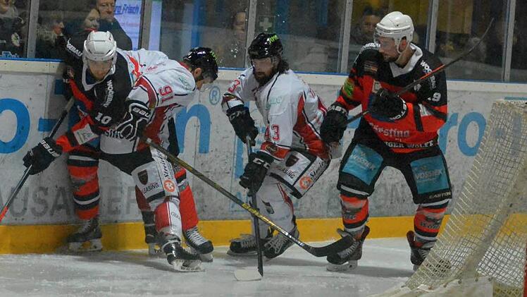 Fight an der Bande: Niko Grönstrand (links) und Wölfe-Kapitän Simon Eirenschmalz blocken zwei Königsbrunner.  Foto: EHC