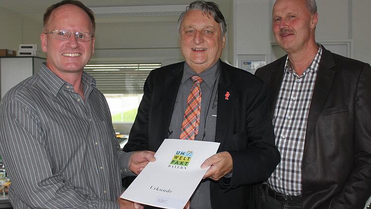Landrat Eberhard Irlinger (rechts) überreicht die Urkunde. Auch Bürgermeister Gerald Brehm war vor Ort. Foto: Sabine Herteux