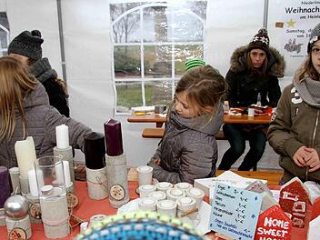 Die Niederlindacher Bastelkids verkauften nicht nur selbst gestaltete Teelichter, Kerzenst&auml;nder und andere Dekoartikel, sondern luden die Besucher des Weihnachtsmarktes auch dazu ein, an ihrem Stand einen Stern zu basteln. Foto: Richard S&auml;nger