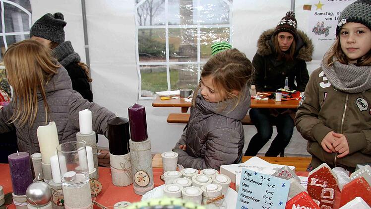 Die Niederlindacher Bastelkids verkauften nicht nur selbst gestaltete Teelichter, Kerzenst&auml;nder und andere Dekoartikel, sondern luden die Besucher des Weihnachtsmarktes auch dazu ein, an ihrem Stand einen Stern zu basteln. Foto: Richard S&auml;nger