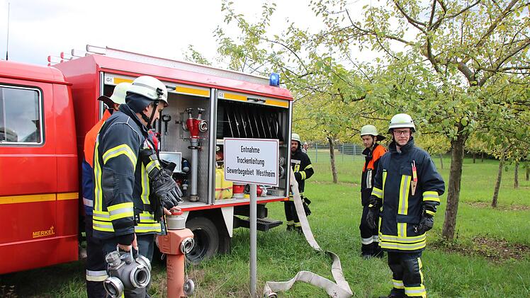 Mitglieder der Langendorfer Wehr warten am oberen Ende der Trockenleitung auf Wasser aus der Saale. Foto: Ralf Ruppert
