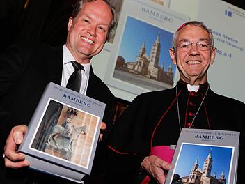 Generalkonservator Mathias Pfeil und Erzbischof Ludwig Schick präsentieren die beiden Bände der neuen Publikation zur Baugeschichte des Bamberger Doms. Foto: Matthias Hoch
