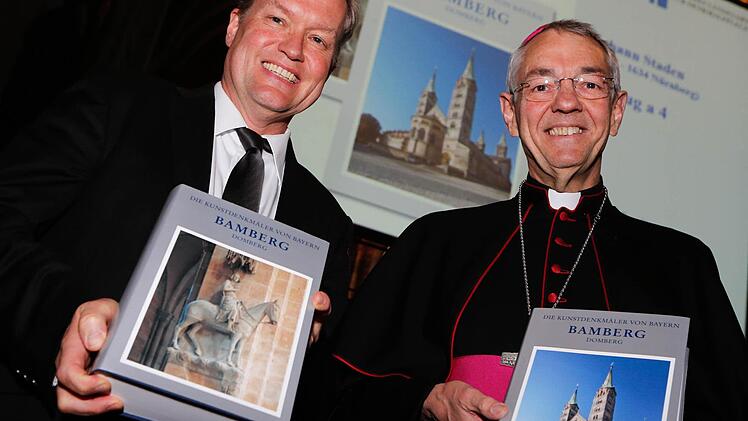 Generalkonservator Mathias Pfeil und Erzbischof Ludwig Schick präsentieren die beiden Bände der neuen Publikation zur Baugeschichte des Bamberger Doms. Foto: Matthias Hoch