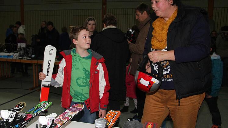 Philipp Nagel (8) hat sich rot-weiße Skier ausgesucht, einen Helm und Skischuhe. Mama Bianca ist begeistert von der Auswahl.