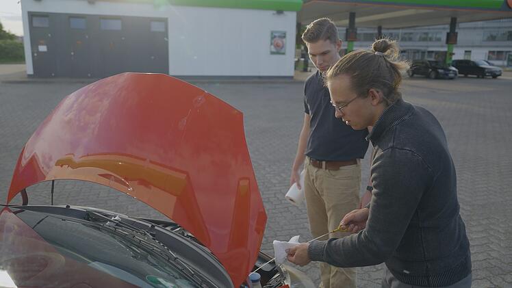 Vor Reiseantritt checkt Felix (rechts) noch einmal sein Auto.
