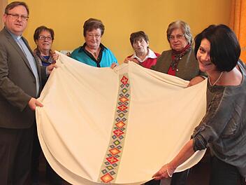 Pfarrer Thomas Ringer und Gertrud Stubenvoll (r.) vom Adelsdorfer Missionskreis freuen sich, dass die Stickerinnen um Inge Rehäußer (4. v. l.) das Messgewand rechtzeitig fertig bekommen haben. Foto: Johanna Blum