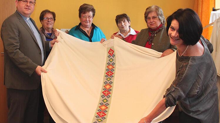 Pfarrer Thomas Ringer und Gertrud Stubenvoll (r.) vom Adelsdorfer Missionskreis freuen sich, dass die Stickerinnen um Inge Rehäußer (4. v. l.) das Messgewand rechtzeitig fertig bekommen haben. Foto: Johanna Blum