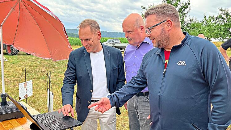 Von links: Landrat Mario G&ouml;tz und B&uuml;rgermeister von Aura, Martin Kaiser, lassen sich das KI-gest&uuml;tzte System vor Ort von Hartmut Vierle (Zukunftslabor, Landkreis Bad Kissingen) erkl&auml;ren. Landkreis Bad Kissingen/Lena Metz