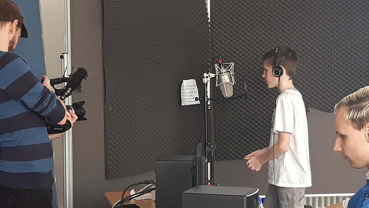 "Achtung, Aufnahme": Voll konzentriert singt Dominik Foster (Mitte) seinen Text ein. Links Dennis Steib von "VDSIS" an der Kamera, rechts Timm Fütterer, der ausführende Produzent und Postproduction. Foto: Ralf Naumann