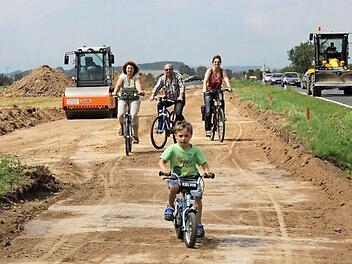 Eine erste Testfahrt: Zum offiziellen Spatenstich fuhren der kleine Finn, Elfriede und Werner Müller sowie Roswitha Günther (dahinter von links) auf der neuen Trasse des Radwegs, der künftig Aidhausen mit Wettringen verbindet und auch für den Landkreis Haßberge von Bedeutung ist.