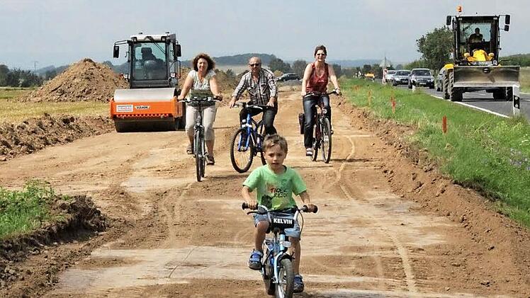 Eine erste Testfahrt: Zum offiziellen Spatenstich fuhren der kleine Finn, Elfriede und Werner Müller sowie Roswitha Günther (dahinter von links) auf der neuen Trasse des Radwegs, der künftig Aidhausen mit Wettringen verbindet und auch für den Landkreis Haßberge von Bedeutung ist.