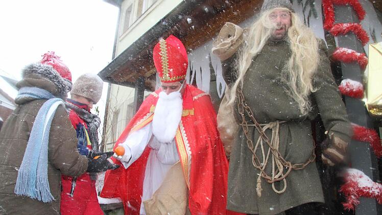 Der Nikolaus verteilt Gaben an die Kinder.