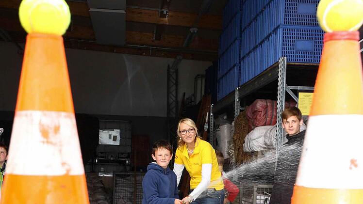 Den Tennisball mit dem Wasserstrahl treffen: Jonas Löhlein mit Betreuerin Ramona Bunzelt beim Zielspritzen.  Foto: Stefan LUtter