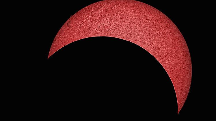 So sah die Sonne mit maximaler Bedeckung über Bamberg aus. Aufgenommen von Markus Schindewolf (Sternwarte Bamberg) mit einem speziellen Teleskop. Der Filter lässt nur den Teil des Lichts durch, der eine ganz bestimmte Wellenlänge (=Farbe) hat, die vom Wasserstoff in der Sonne erzeugt wird.