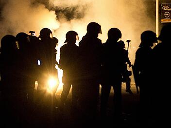 Polizei sichert am 21.08.2015 den ehemaligen Praktiker Baumarkt in Heidenau (Sachsen) vor Übergriffen von Gegner der Asylunterkunft. In dem seit 2013 leerstehenden Baumarkt in einem Gewerbegebiet sollen in der Nacht zum Samstag etwa 250 Neuankömmlinge untergebracht werden. Foto: Arno Burgi/dpa
