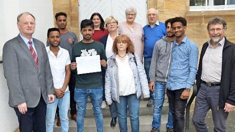 Der Diakonieverein überreichte 700 Euro an den Unterstützerkreis. Mit im Bild sind Pfarrer Reinhold König (links), Ursula Eberle-Berlips, Gabi Scharf, Franz-Josef Förster, Udo Baumann sowie Bewohner der Gemeinschaftsunterkunft und Mitglieder des Diakonievereins.  Foto: Hofmann