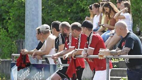 Die Ersatzspieler des ASV Herrnsdorf/Schlüsselau und ihre Anhänger verfolgen das Geschehen.