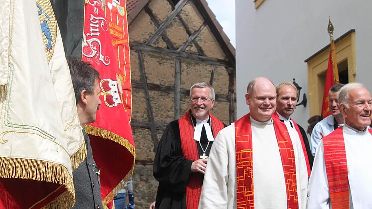 Die Fahnen der Rüdenhäuser Vereine säumten den Auszug von Regionalbischof Christian Schmidt (hinten) mit Pfarrer Martin Fromm, Pfarrer Ernst-Ludwig Werner (vorne von links) und Dekan Günter Klöss-Schuster.  Fotos: Zapf