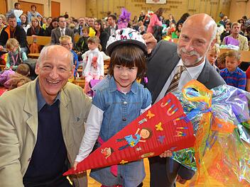 Julia, die am Donnerstag in der Henneberg-Grundschule eingeschult wurde, war eine von rund 160 Erstklässlern, die von Joachim Galuska (l.) und OB Kay Blankenburg (r.) einen Fahrradhelm bekam. Foto: Peter Rauch
