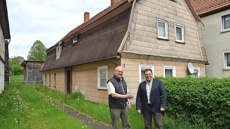 Dieses Haus am Dorfplatz in Reitsch und die dahinter befindliche Scheune werden abgerissen. An seiner Stelle soll ein grünes Kleinod in der Dorfmitte entstehen, so Zweiter Bürgermeister Siegfried Weißerth (links) und Geschäftsleiter Rainer Förtsch. Foto: K.- H. Hofmann