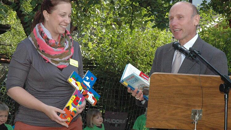 Mit einem Kreuz und einer kindgerechten Bibel bedankte sich Pfarrer Stephan Aupperle (rechts) bei der Kindergartenleiterin Yvonne Schober (links) für die engagierte Arbeit des Teams.