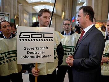 Der Vorsitzende der Lokführergewerkschaft GDL, Claus Weselsky unterhält sich am Samstag auf dem Hauptbahnhof in Leipzig mit streikenden Lokführern. Die GDL will ihren Ausstand am Samstagabend beenden - früher als geplant. Foto: Hendrik Schmidt/dpa