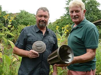 Kurt Heid und Fritz Gensler laden zum Sommerfest des Diebacher Gartenbauvereins ein und fragen sich, was wohl der Zweck dieses Behälters gewesen war.  Foto: Elisabeth Assmann