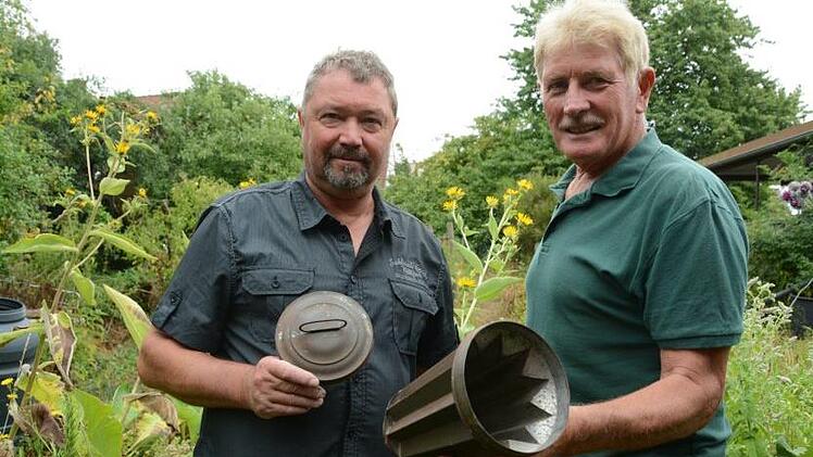 Kurt Heid und Fritz Gensler laden zum Sommerfest des Diebacher Gartenbauvereins ein und fragen sich, was wohl der Zweck dieses Behälters gewesen war.  Foto: Elisabeth Assmann