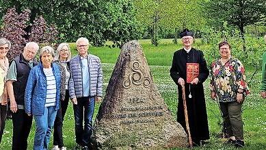 Einige Teilnehmer begaben sich mit „Pfarrer Schöppner“ ( Jochen Bock) zum Gedenkstein, der im Kurpark von Bad Bocklet steht.