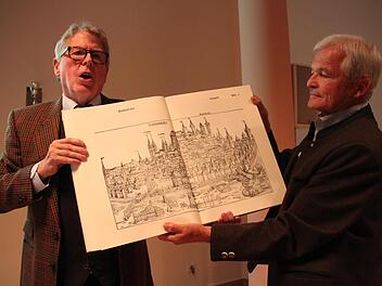 Jürgen Zinck (links) und Dr. Bernd Matthes zeigen das Bild der Stadt Nürnberg aus der Schedelschen Weltchronik aus dem Jahre 1493. "Sie war eines der ersten erfolgreichen Buchprojekte. Darin wurde die Welt räumlich und zeitlich erfasst", erläuterte Zinck.  Fotos: Stephan Stöckel