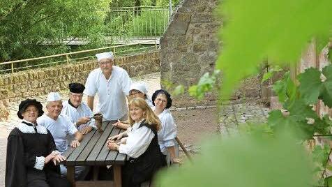 Alle sieben Darsteller an einem Tisch