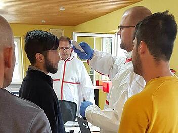 Screening durch das BRK in der Erstaufnahmeunterkunft in der Unteren Kellerstraße: Zur Basisuntersuchung der Flüchtlinge gehört auch das Messen der Körpertemperatur.  Foto: BRK