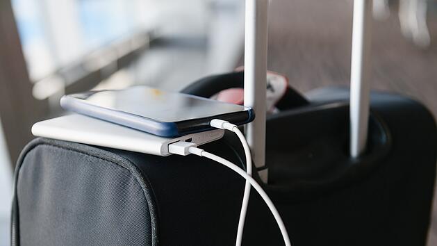 Smartphone charging from power bank on suitcase Aufladen des Smartphones &uuml;ber die Powerbank im Koffer