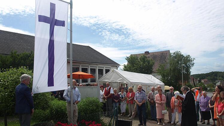 Im Rahmen des Sommerfestes segnete Pfarrer Philipp Klein die neue Fahne der evangelischen Kirchengemeinde Oerlenbach. Foto: Stefan Geiger