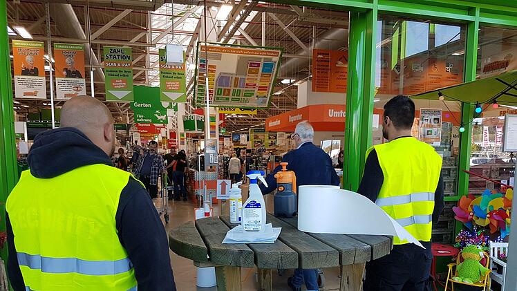 Bei Globus stehen Security-Mitarbeiter im Eingangsbereich.