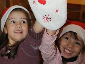 Zoey und Valentina fühlen mal: Ist schon was drin, im Nikolausstrumpf?  Foto: Diana Fuchs