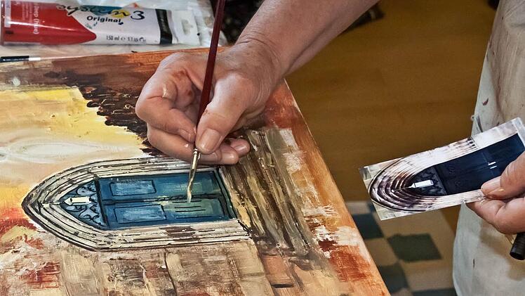 Fotografiertes Original und künstlerisches Abbild: der Haupteingang der Stadtkirche St. Georg, gemalt von Elfi Hübner.