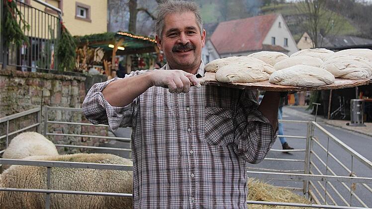 Nachschub: Stefan Hofbauer bringt eine neue Ladung Brotteig auf einem großen Brett. Idyllisch ging es zu beim Weihnachtsmarkt rund um die Pfaffenhausener Linde. Alle packten mit an und so entstand eine familiäre Gemütlichkeit. Fotos: Gerd Schaar