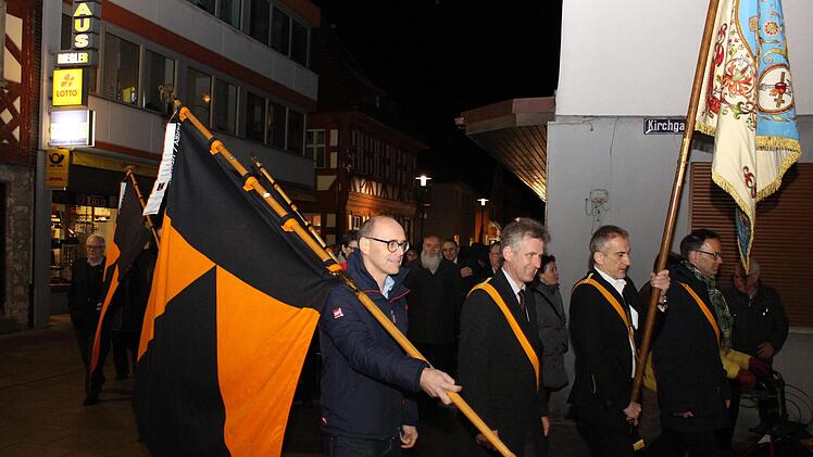 Die schwarz-orangefarbenen Kolpingfahnen wurden dem Zug vorangetragen. Alexander Schulz (Zweiter von rechts) trägt die historische Fahne des katholischen Arbeitervereins