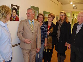 (von links) Pflegedienstleiterin Karin Büttner,  Helmut Weiß, Claudia Welsch, Katja Suffa-Weißkopf, Dagmar Alfsmann (Leiterin der Altenpflegeschule) sowie Heinrich Weiß bei der Vernissage. Das Bild (zwischen Karin Büttner und Helmut Weiß) zeigt die verstorbene Ilse Weiß, die die  Bilder gemalt hat.