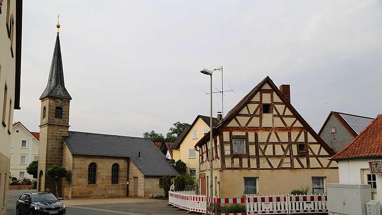 Das alte Gemeindehaus (r.) steht im Ensemble mit der Filialkirche im Dorfzentrum von Dobenreuth. Foto: Franz Galster
